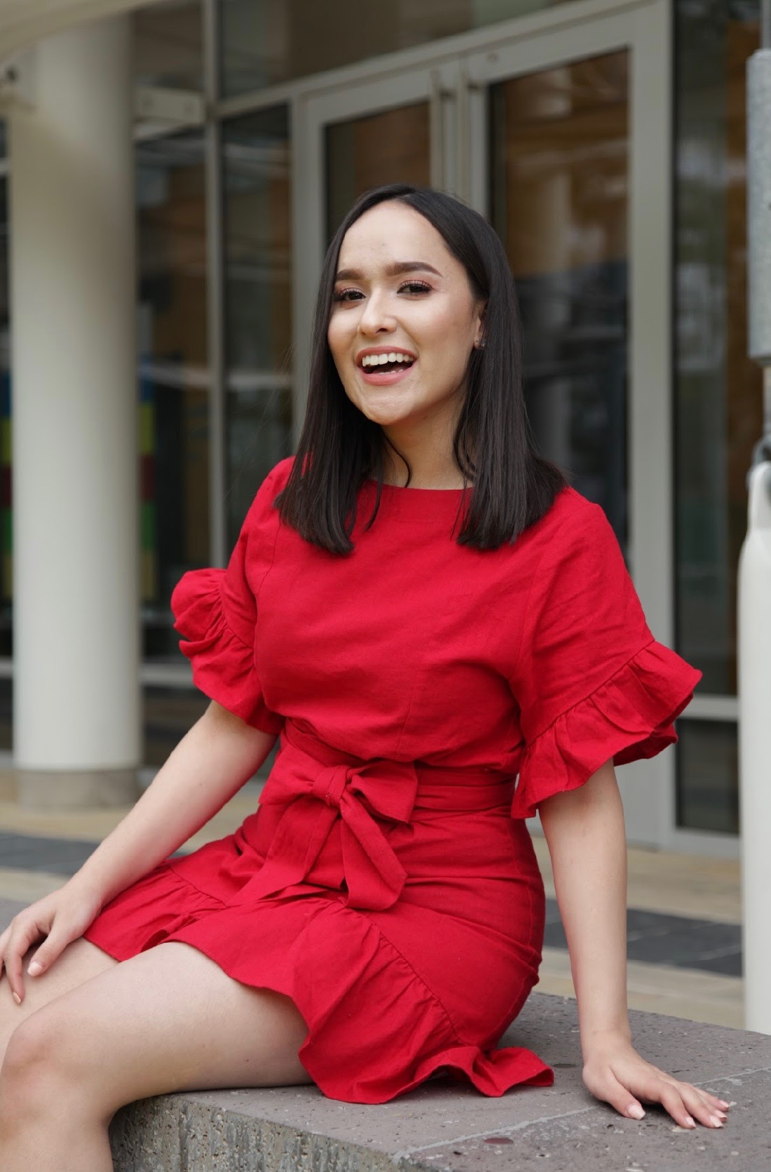 Melissa smiling in a bright red dress